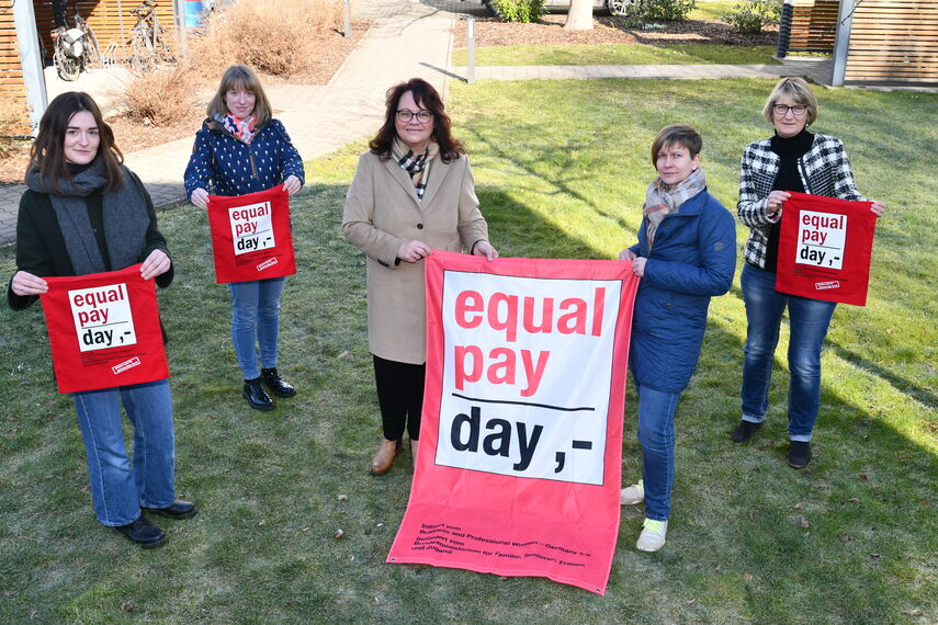 5 Frauen halten Fahnen zum Thema equalpayday in den Händen.